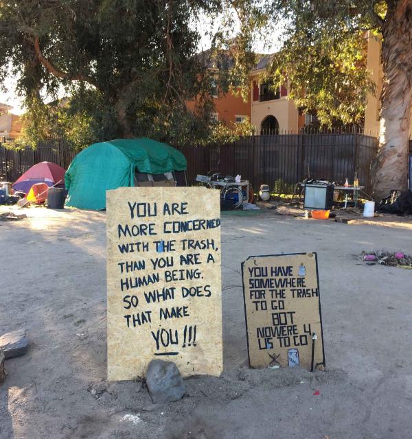 Signs posted by homeless people at an encampment. 
